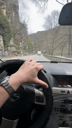 Driver navigates mountain road in Opel near Bachkovo, Bulgaria