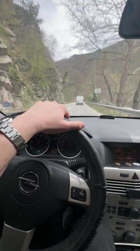 Driver navigates mountain road in Opel near Bachkovo, Bulgaria