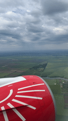 Passenger documents flight views from red-white aircraft window