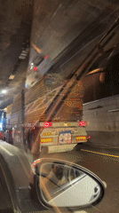 Vehicle follows lumber truck through tunnel