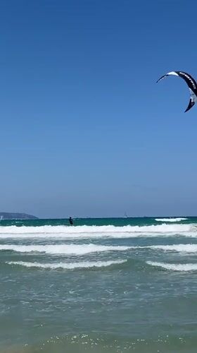 Kitesurfing session and beach activities captured in Acre, Israel