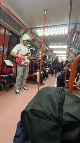 Street musician performs electric guitar on Buenos Aires subway