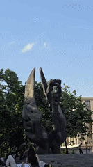Afternoon gatherings documented around winged statue in public space