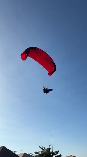 Paragliders fill the sky over Kuta Selatan's coastal cliffs
