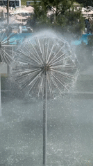 Dandelion-shaped metal fountain spraying mist into the air