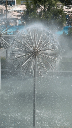 Dandelion-shaped metal fountain spraying mist into the air