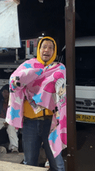 Man spotted smiling outdoors wrapped in cartoon blanket