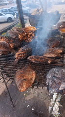Fresh fish grilling over open coals at a Nigerian outdoor spot