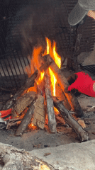 Person tends outdoor fire in stone oven, Montenegro