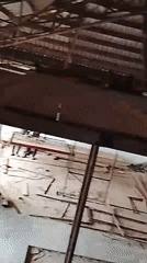 Construction site interior with wooden roof beams documented