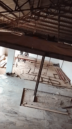 Construction site interior with wooden roof beams documented