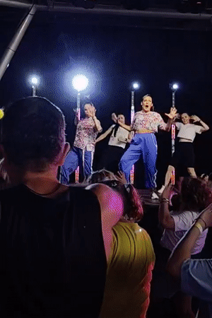 Zumba session: instructors on stage, crowd dancing along below