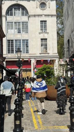 Pedestrians walk cobblestone street in London