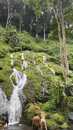 Tourists photograph at waterfall in Kintamani, Indonesia