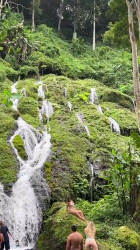 Tourists photograph at waterfall in Kintamani, Indonesia