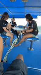 Diving instructor demonstrates equipment to boat passengers in Thailand