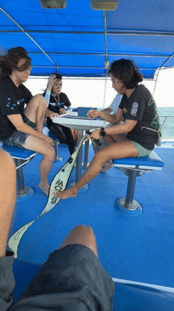 Diving instructor demonstrates equipment to boat passengers in Thailand