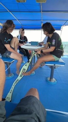Diving instructor demonstrates equipment to boat passengers in Thailand