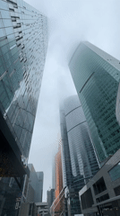 Fog shrouds Moscow skyscrapers as pedestrians navigate city streets