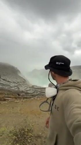 Tourists visit volcanic crater with turquoise lake in Indonesia