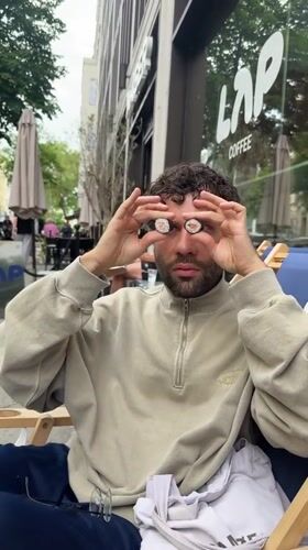 Man playfully holds sushi as glasses outside Berlin coffee shop