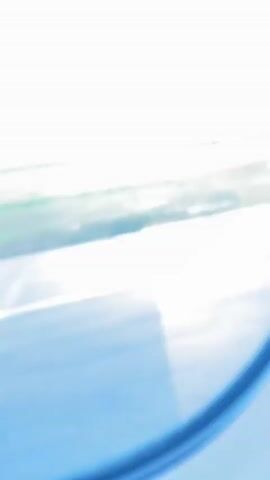 A blurry, high-angle video shows a bright sky and a runway below. A red and white airplane appears in the distance, then closer, as it taxis on the tarmac. A large airplane engine is visible in the foreground of the frame.