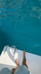 Tourist documents morning yacht cruise around Capri's Faraglioni rocks