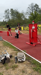 Boys operate water hoses on athletic track in Kazanlak