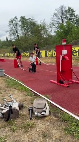 Boys operate water hoses on athletic track in Kazanlak