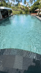 Resort guest documents early morning poolside relaxation in Ubud