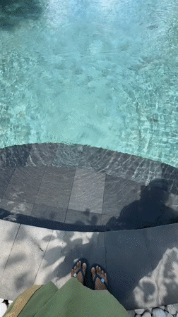Resort guest documents early morning poolside relaxation in Ubud