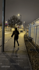Woman skips playfully along Belgrade sidewalk at night