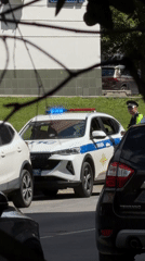 Police SUV parked roadside in Khimki, officer standing by