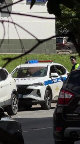 Police SUV parked roadside in Khimki, officer standing by