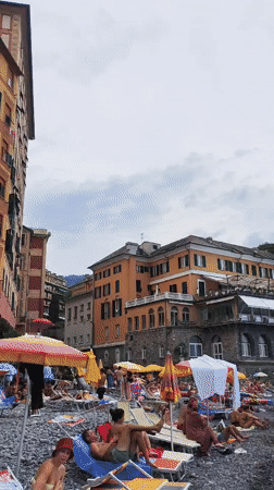 Busy summer afternoon on Camogli's pebble beach, Liguria