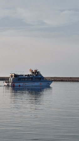 Tourists photograph Mediterranean coastline scenes in Dénia, Spain