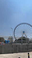 Ferris wheel operates under sunny skies in Puebla