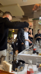 Restaurant celebration features four men, Cyrillic name card observed