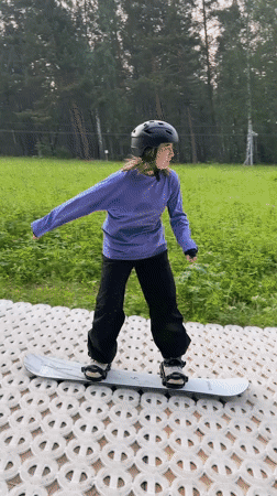 Dry slope snowboarding session on a summer hillside in Divnogorsk