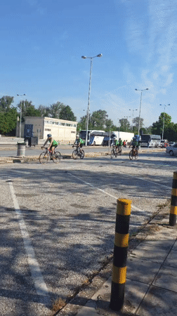 Five cyclists in green ride through Greek town