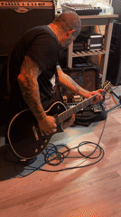 Electric guitar session in a poster-covered punk music space