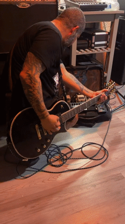 Electric guitar session in a poster-covered punk music space