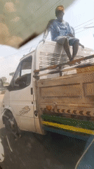 Nigerian roadside scenes: truck rider and fruit vendor captured