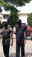 Film crew stages production scene with masked actors, SUV