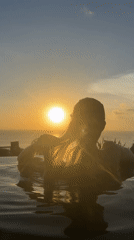 Woman enjoys pool sunset at busy Kuta Selatan resort