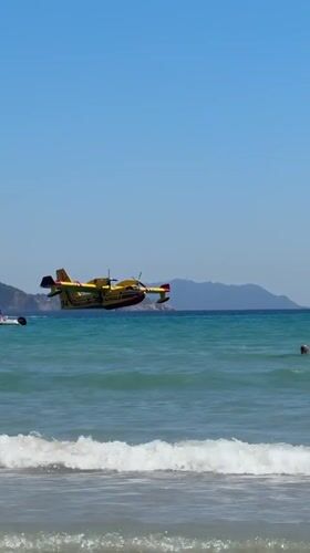 Firefighting plane drops water over crowded La Ciotat beach