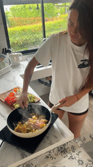 Woman cooks vegetable meal in Ban Bang Rak kitchen