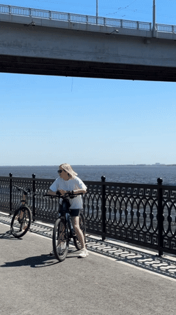 Women with bicycles gather on sunny Saratov riverbank