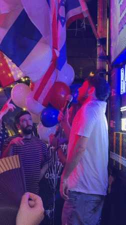 Crowded bar night in Tel Aviv, flags and live singing