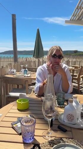 Woman enjoys beachside dining experience in Ramatuelle, France